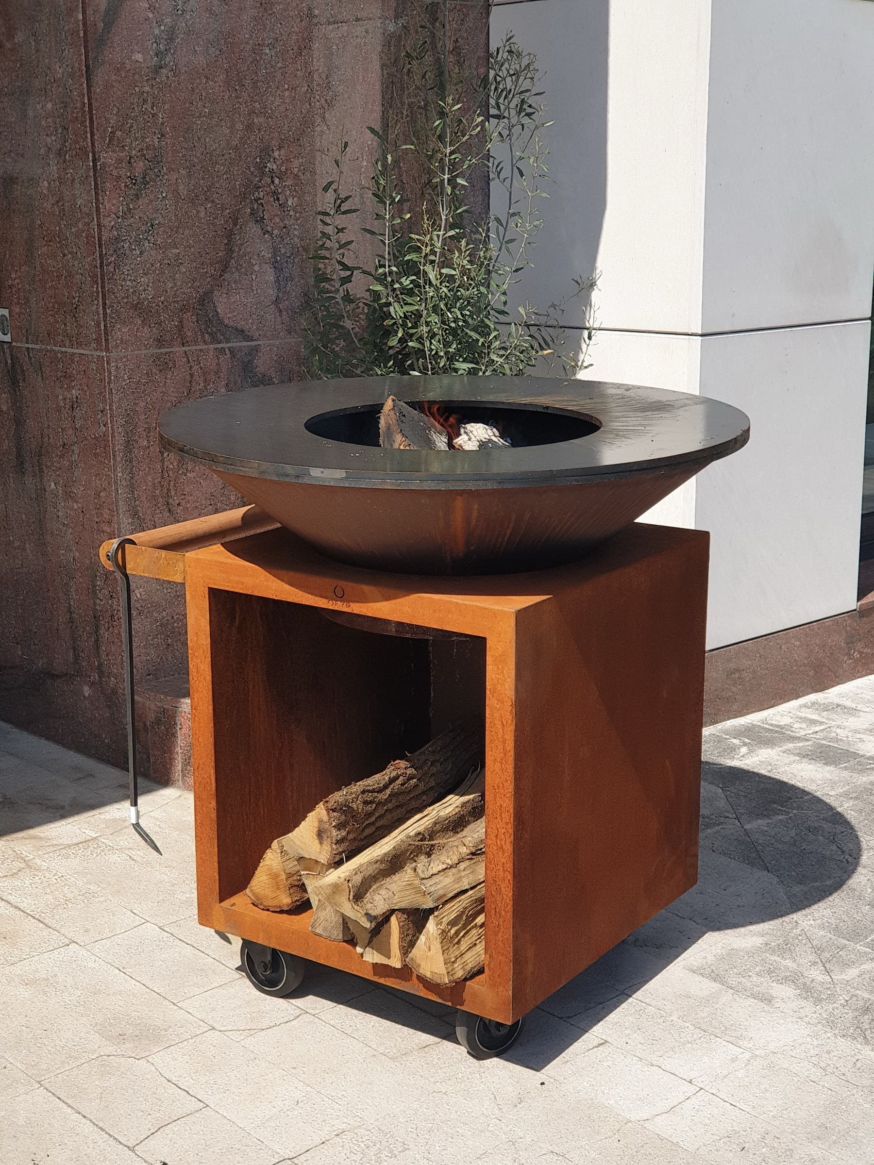 Barbecue OFYR avec rangement à bois intégré et brasero allumé